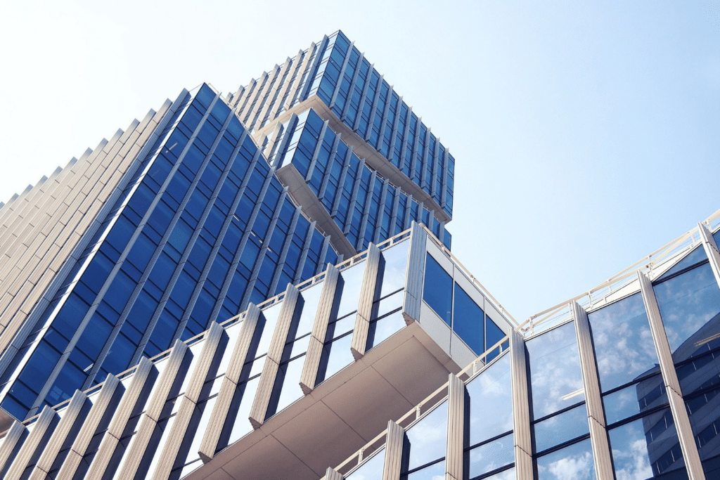 Hochhaus von unten fotografiert mit blauen Himmel, TItelbild für den Beitrag "Erfolgreiches Asset-Management von Hotelimmobilien"